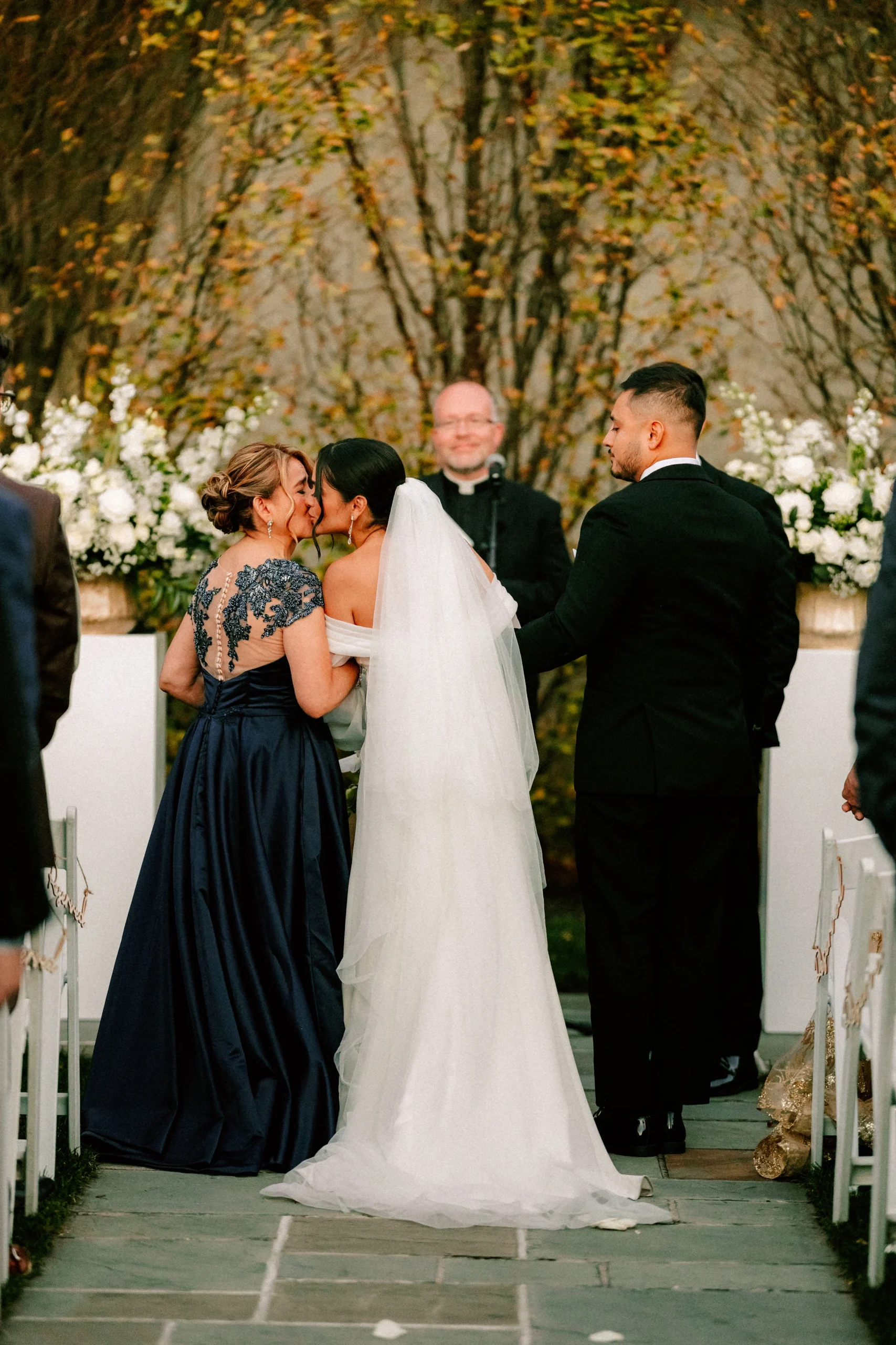 Bride shares a kiss with her mother at the altar as the ceremony concludes.