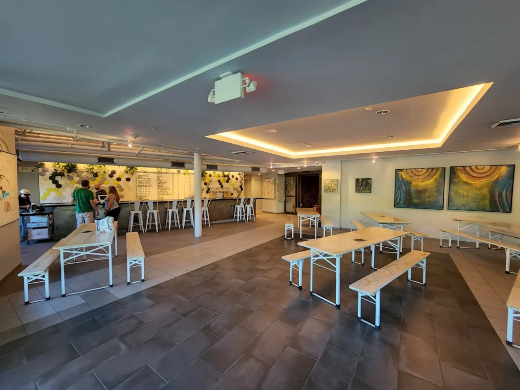 Modern café interior with communal tables, bar seating, and menu counter.